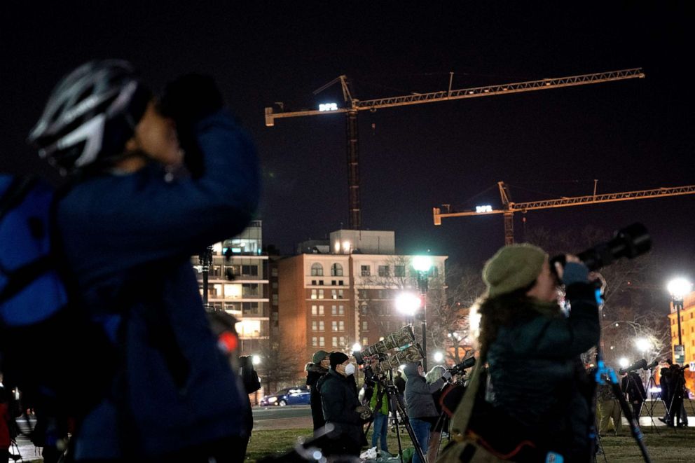 PHOTO: Birdwatchers take photos of a rare snowy owl near Union Station in Washington D.C., on Jan. 12, 2022.