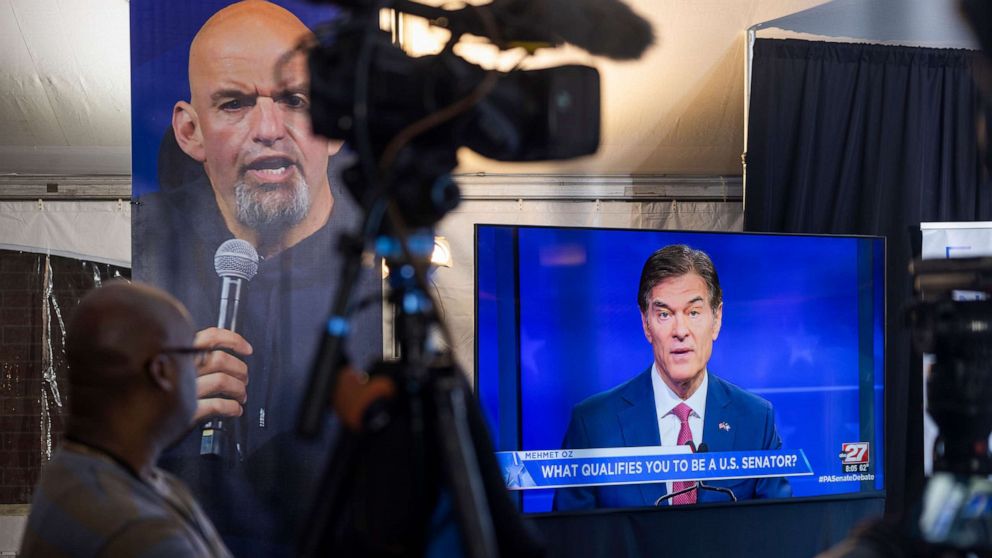 PHOTO: Members of the media watch Republican nominee Mehmet Oz on a television monitor as he takes on Democratic Senate nominee for Pennsylvania John Fetterman during the candidates' only debate in Harrisburg, Penn. October 25, 2022.