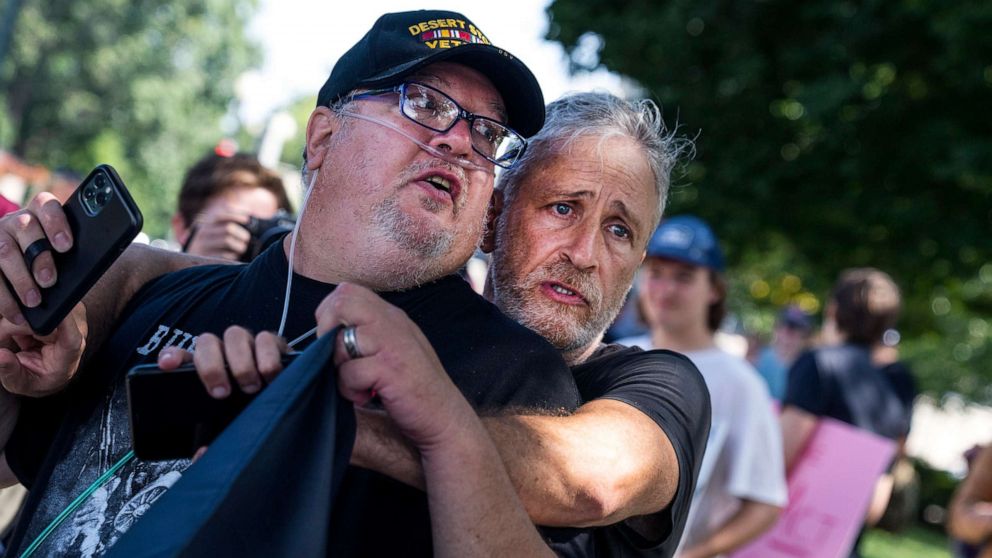 PHOTO: Jon Stewart hugs Tim Hauser, an Air Force veteran, at a rally to call on the Senate to pass the Pact Act, which aims to expand health care and benefits to veterans exposed to toxins while serving, outside the Capitol in Washington, Aug., 2, 2022.