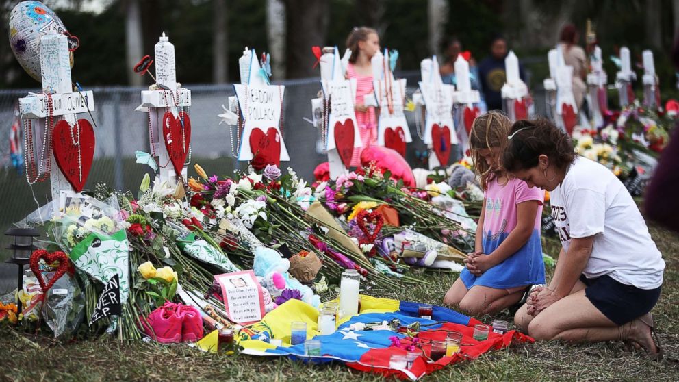 People visit a makeshift memorial setup in front of Marjory Stoneman Douglas High School, Feb. 19, 2018, in Parkland, Florida. 