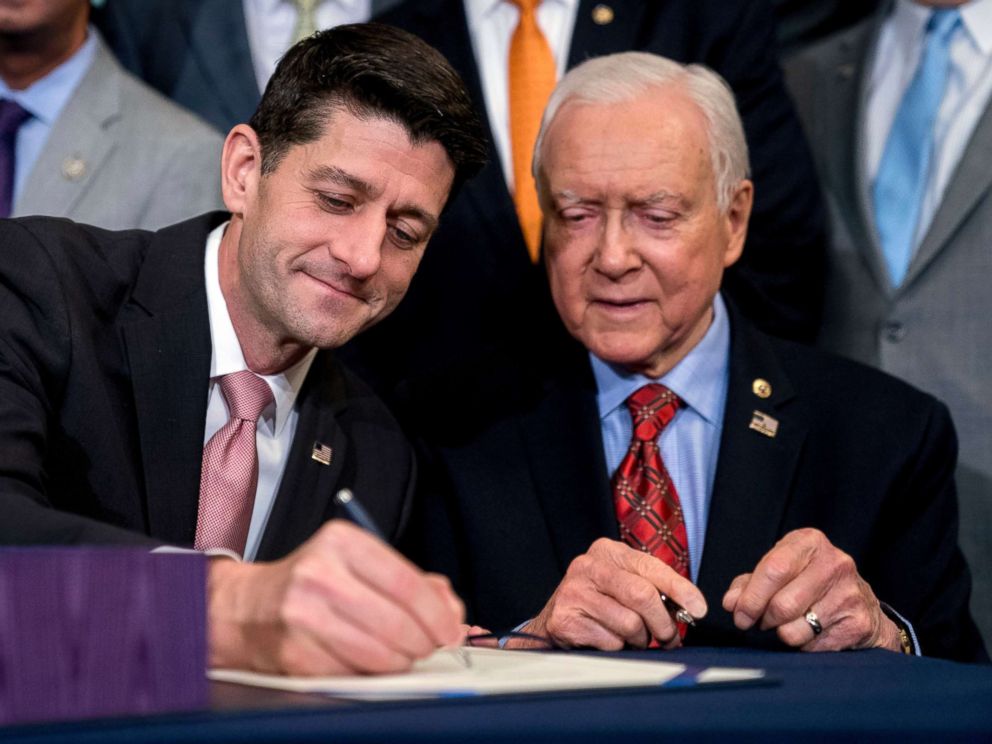 PHOTO: Speaker of the House Paul Ryan accompanied by Senate Finance Committee Chairman Orrin Hatch, right, signs the final version of the GOP tax bill during an enrollment ceremony at the Capitol in Washington, Dec. 21, 2017.