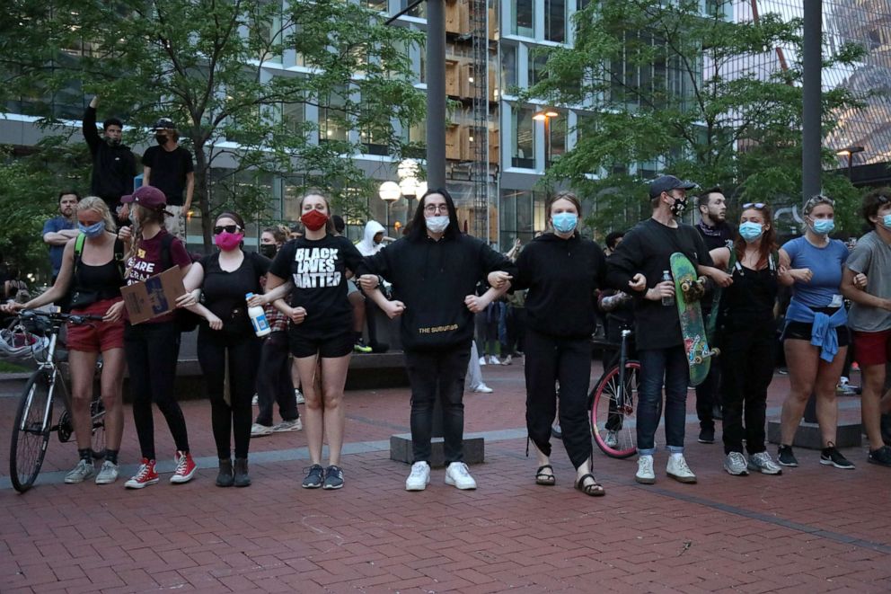 PHOTO: People link arms in front of the Government Center in Minneapolis, to protest the death of George Floyd while in police custody, May 31, 2020.