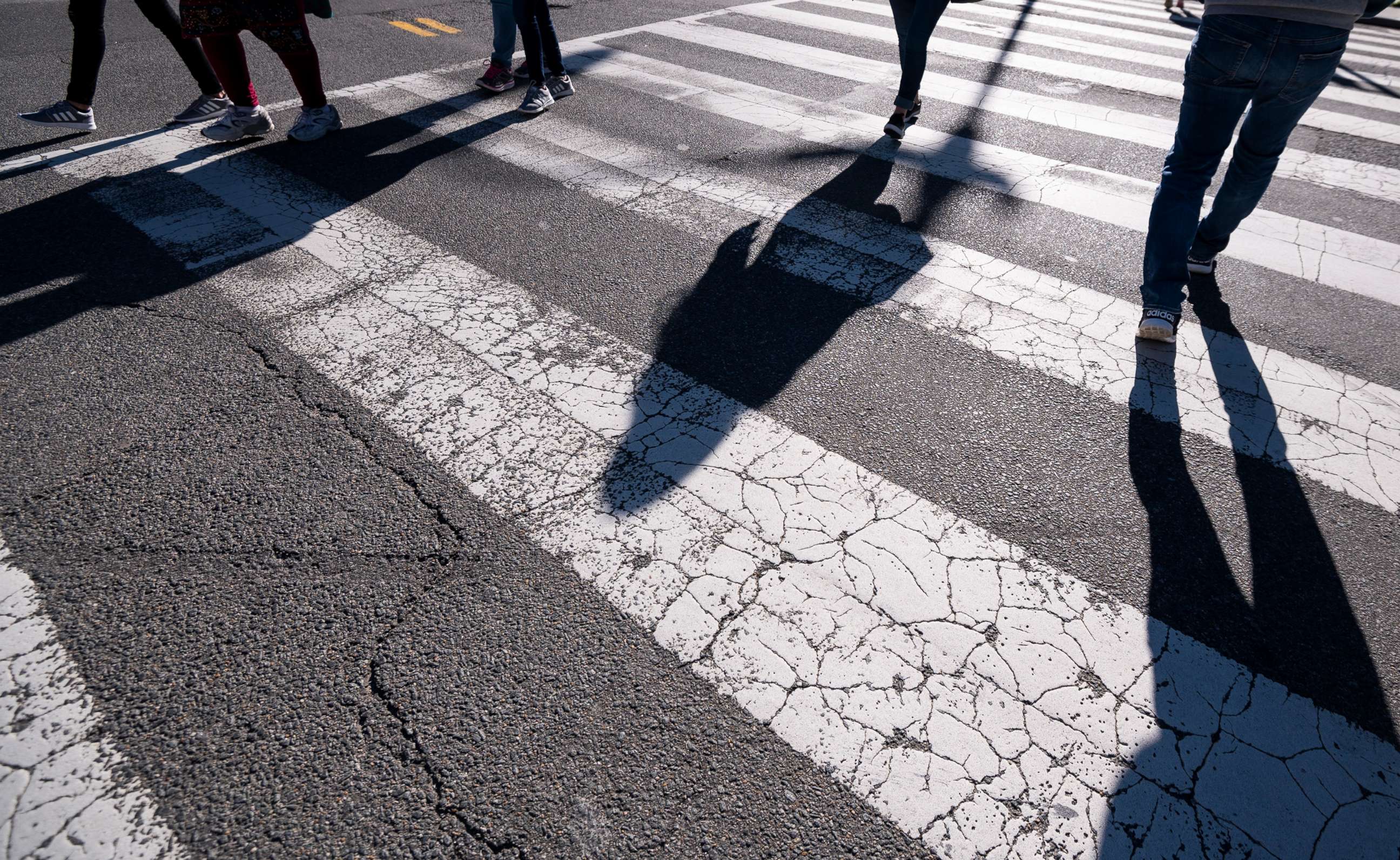 PHOTO:Pedestrians cross the street using a crosswalk in downtown Washington, March 29, 2021. 