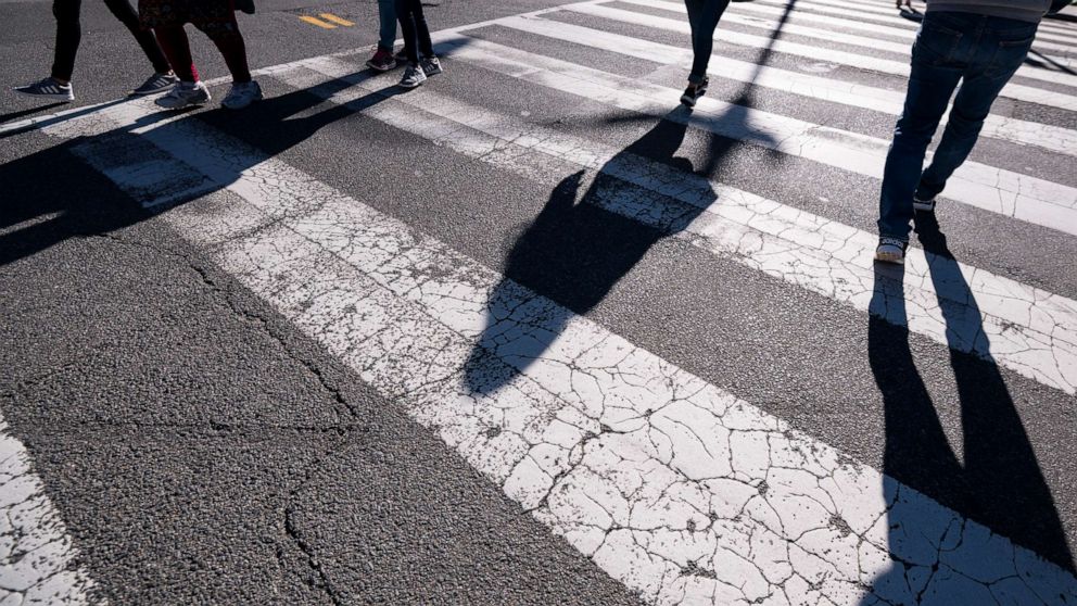 PHOTO:Pedestrians cross the street using a crosswalk in downtown Washington, March 29, 2021. 