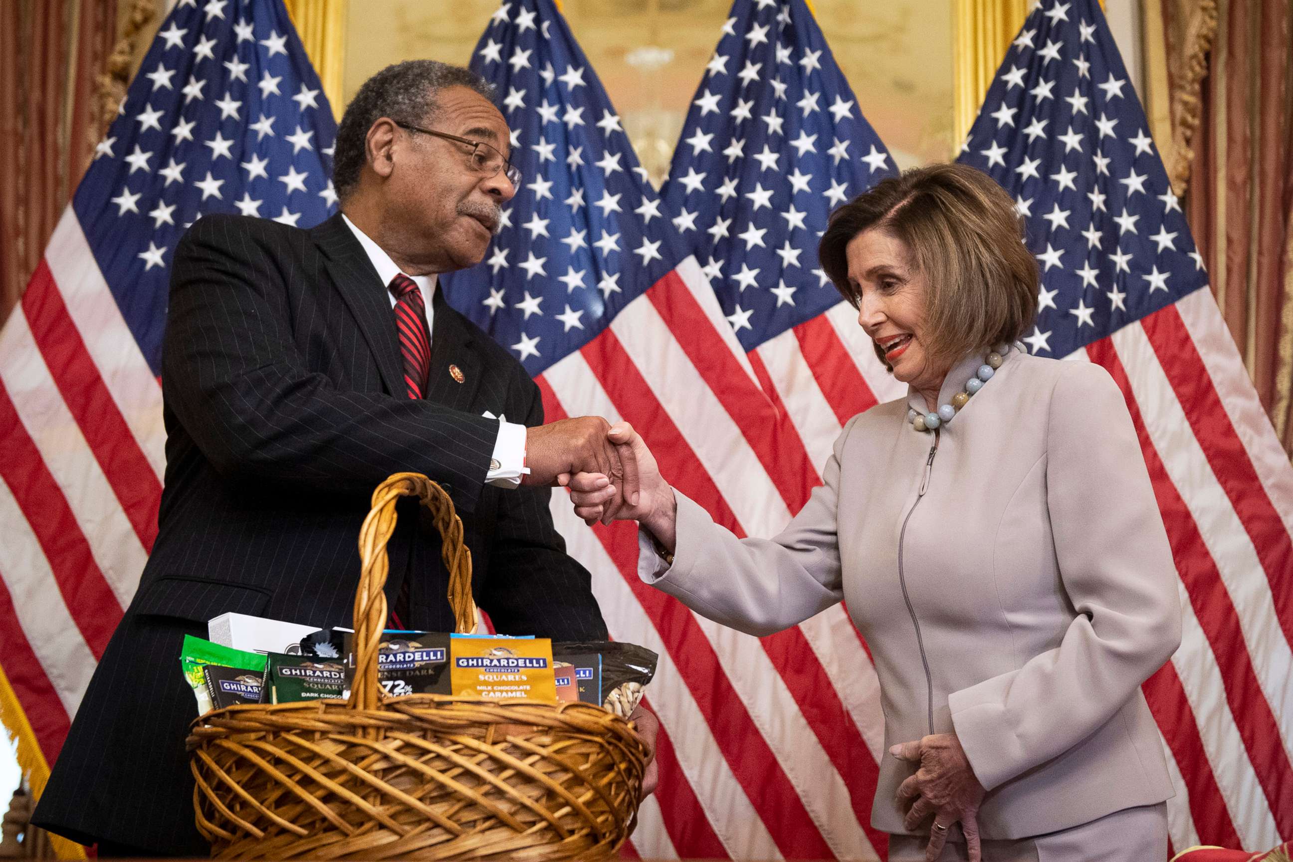 PHOTO: Speaker of the House Nancy Pelosi, right, pays off a friendly wager of California chocolates and nuts to Rep. Emanuel Cleaver, left, after the San Francisco 49ers lost the Super Bowl to the Kansas City Chiefs, at the Capitol, Feb. 11, 2020.