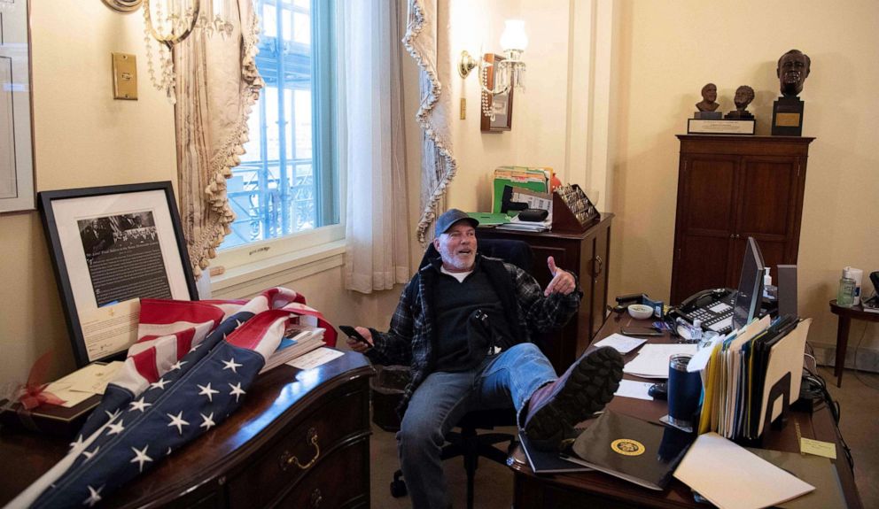 PHOTO: A supporter of President Donald Trump sits inside the office of Speaker of the House Nancy Pelosi after protesters broached the U.S. Capitol in Washington, D.C., Jan. 6, 2021, as Congress met to certify the a 2020 presidential election.