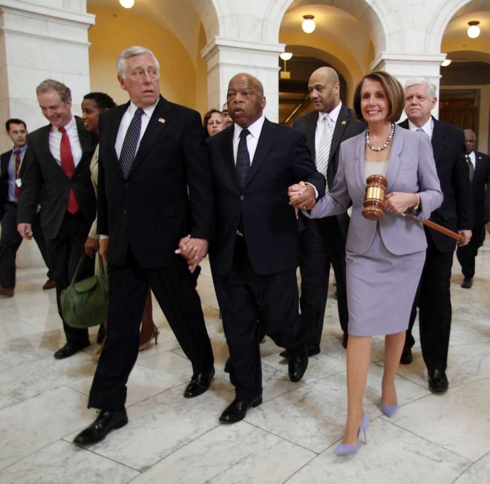 PHOTO: House Speaker Nancy Pelosi holds a large gavel as she walks through the Cannon Rotunda after a Democratic Caucus, along with from left, are Reps. Steny Hoyer, John Lewis, and John Larson, March 21, 2010 on Capitol Hill in Washington.