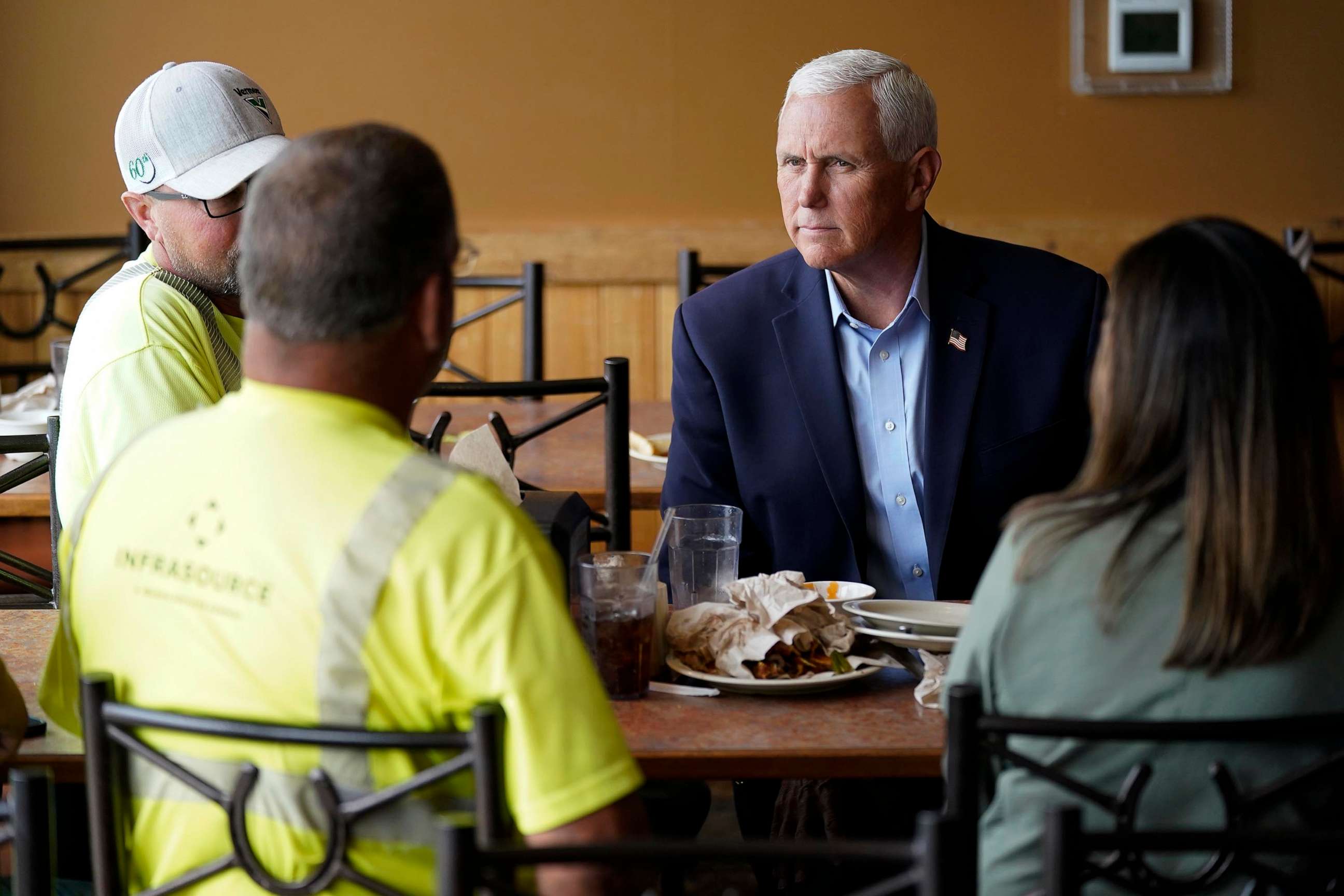 PHOTO: Republican presidential candidate former Vice President Mike Pence talks to local residents during a stop at the Pizza Ranch, on June 8, 2023, in Waukee, Iowa.