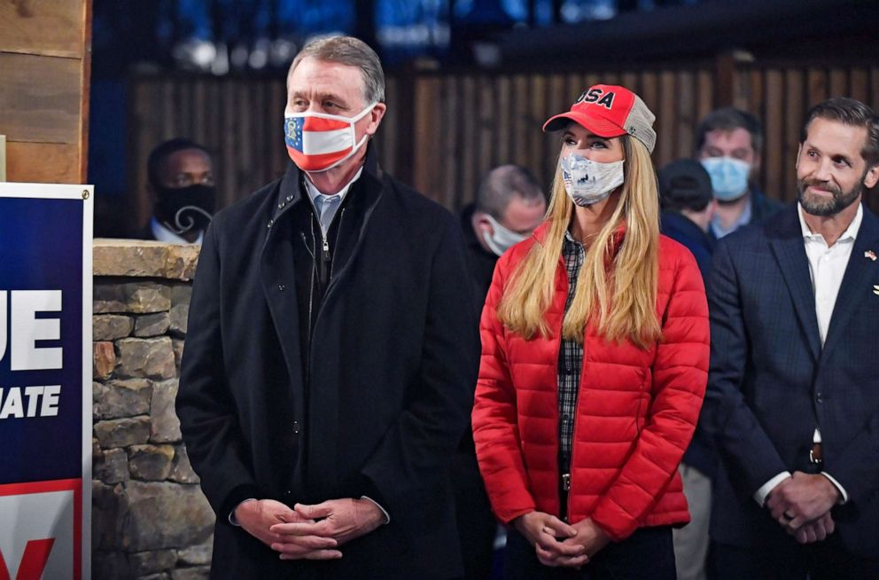 PHOTO: Georgia Senators David Perdue and Kelly Loeffler watch from the side before being introduced during a campaign event on Dec. 20, 2020, at the Reid Barn in Cumming, Ga.