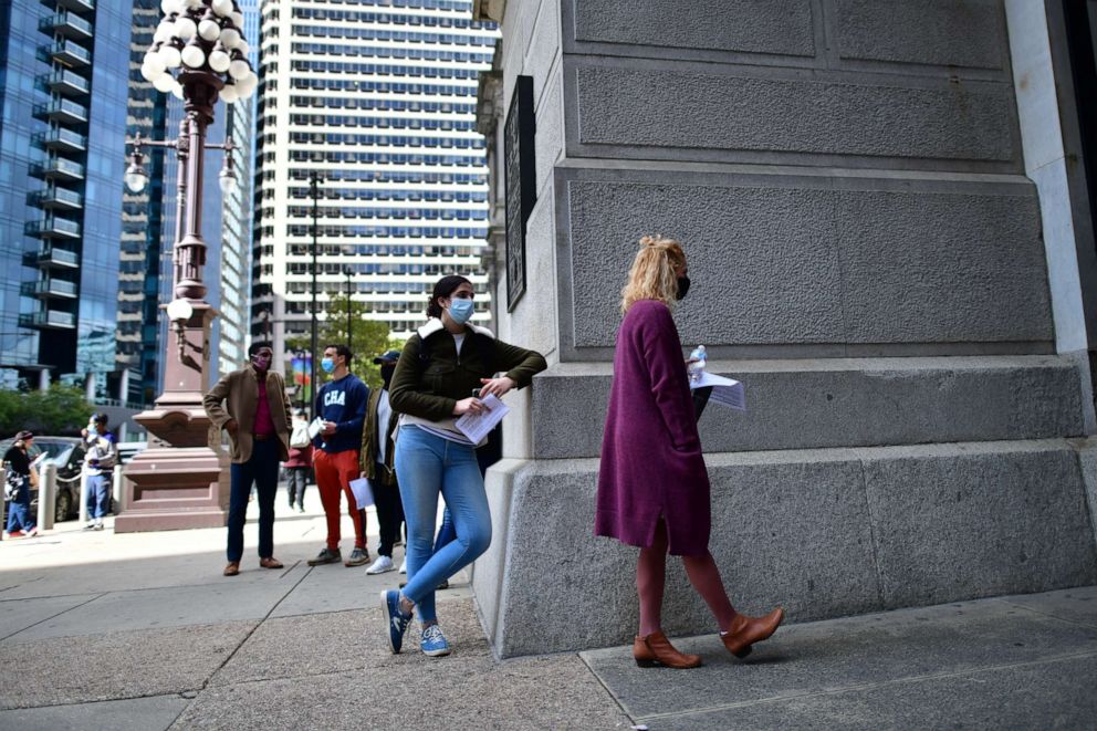 PHOTO: Emily Lipscomb, right, queues outside of Philadelphia City Hall to cast her early voting ballot at the satellite polling station on Oct. 27, 2020, in Philadelphia.