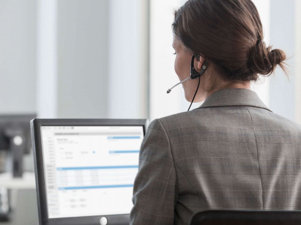 PHOTO: A woman uses a phone headset.