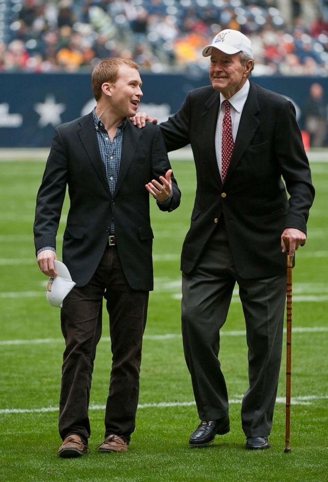 PHOTO: In this Dec. 31, 2009, file photo, former United States President George H. W. Bush, right, leaves the field with the help of Pierce Bush, left, his grandson, before the Texas Bowl NCAA college football game in Houston.
