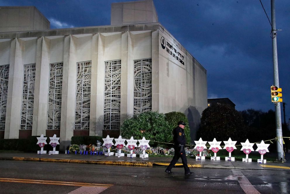 PHOTO: A Pittsburgh police officer passes the Tree of Life synagogue and an improvised memorial in Pittsburgh, October 28, 2018, in memory of those who were killed and injured when a gunman opened fire during the services of the synagogue.