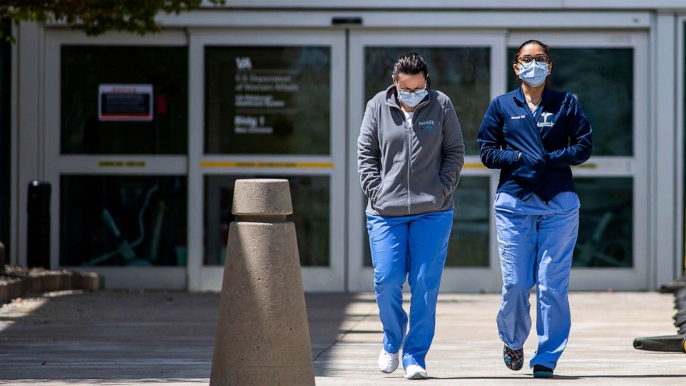 PHOTO: Two woman wearing scrubs and masks exit the Pittsburgh VA Medical Center, April 27, 2020, during the coronavirus outbreak.
