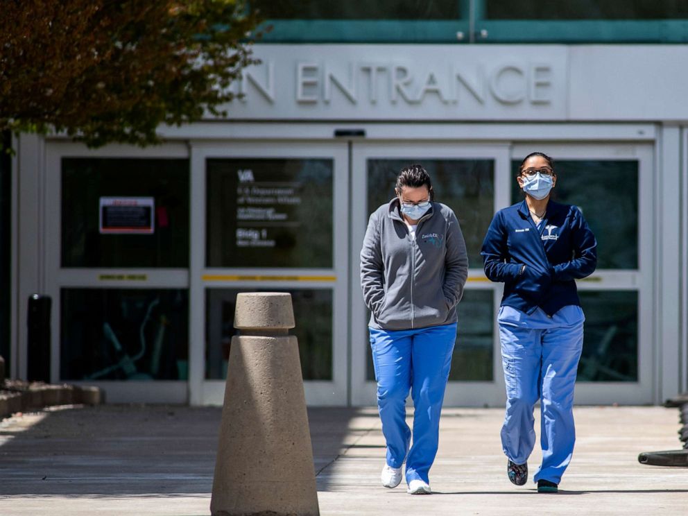 PHOTO: Two woman wearing scrubs and masks exit the Pittsburgh VA Medical Center, April 27, 2020, during the coronavirus outbreak.