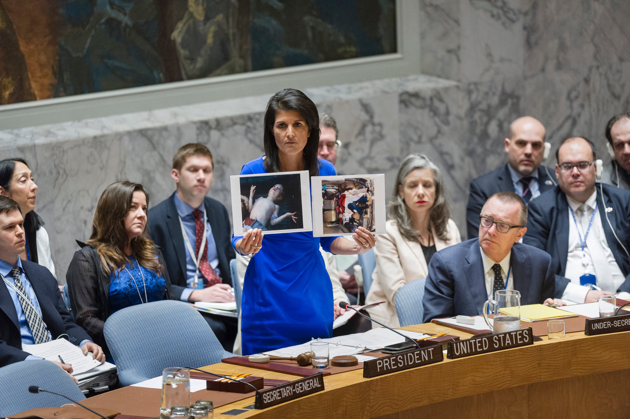 PHOTO: Nikki Haley, United States Permanent Representative to the UN, addresses the UN Security Council on April 5, 2017 in New York, while holding two photographs of Syrian children killed an alleged chemical attack. 