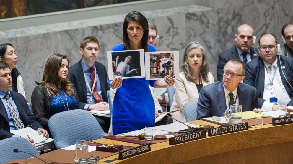 PHOTO: Nikki Haley, United States Permanent Representative to the UN, addresses the UN Security Council on April 5, 2017 in New York, while holding two photographs of Syrian children killed an alleged chemical attack. 