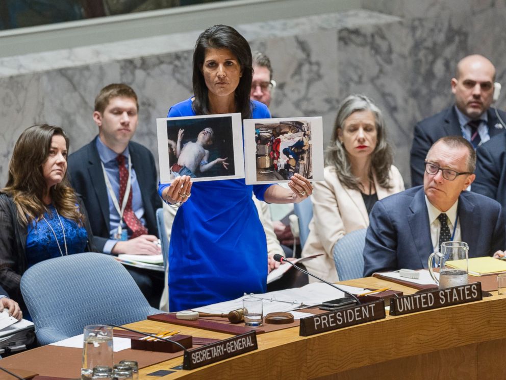 PHOTO: Nikki Haley, United States Permanent Representative to the UN, addresses the UN Security Council on April 5, 2017 in New York, while holding two photographs of Syrian children killed an alleged chemical attack.