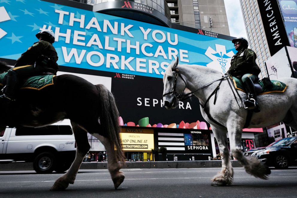 PHOTO: Police ride horses through Times Square as it stands mostly empty as much of the city is void of cars and pedestrians over fears of spreading the coronavirus, March 22, 2020, in New York.