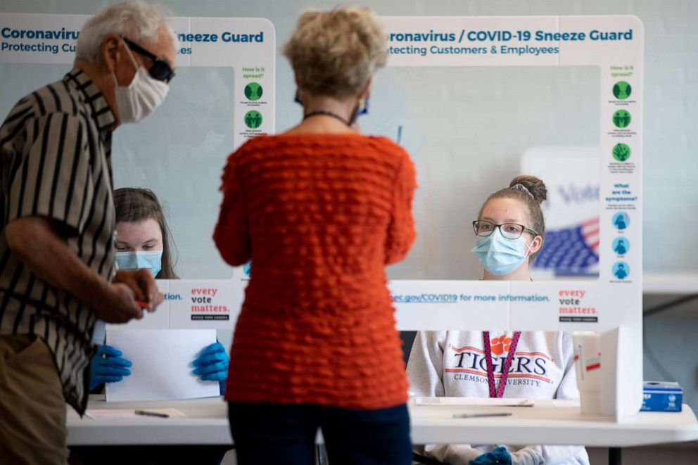 PHOTO: Poll worker Mackenzie Threatt, right, checks in a voter at a polling location on June 9, 2020 in West Columbia, S.C.