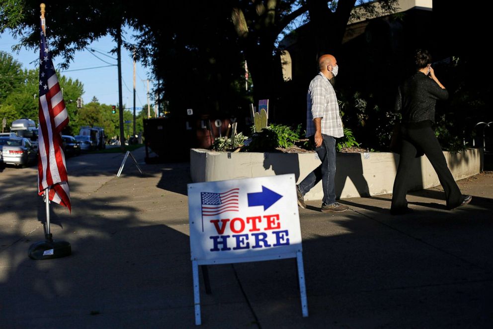 PHOTO: Voters wait in line at a polling station located at Lyndale School on Aug. 11, 2020 in Minneapolis.