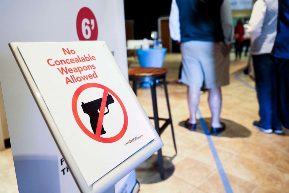 PHOTO: A sign prohibits concealed weapons as people wait to cast their in-person absentee ballots at Seacoast Church West Ashley, Oct. 30, 2020 in Charleston, S.C. 