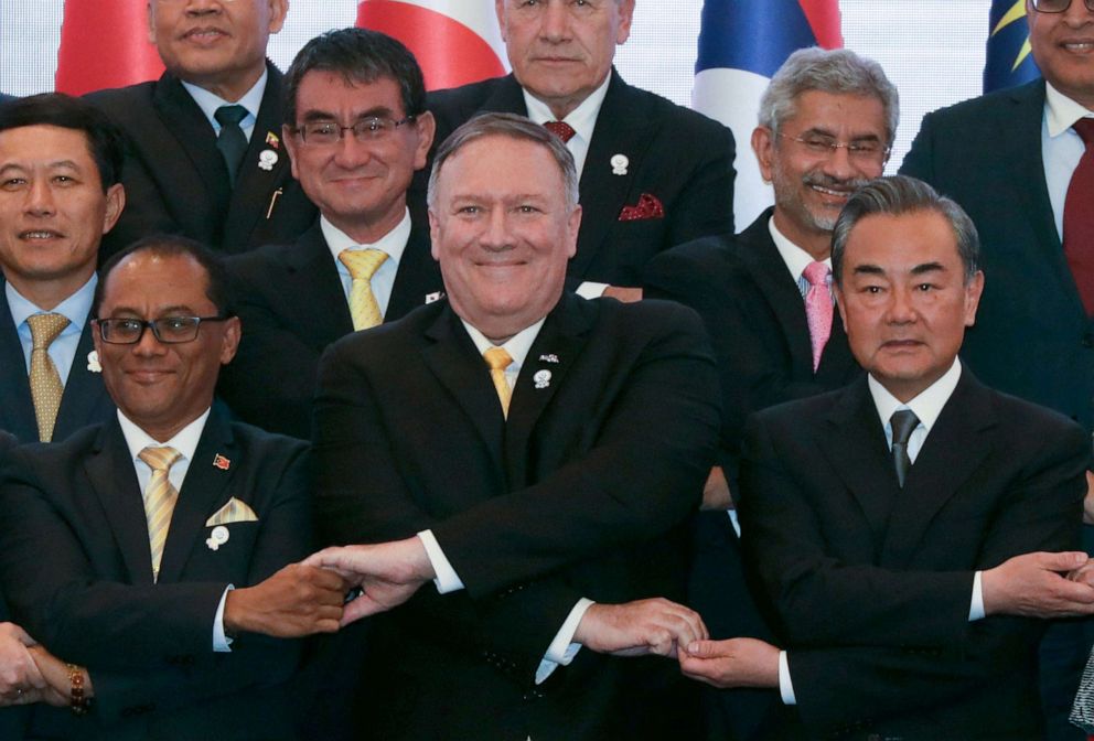 PHOTO: Secretary of State Mike Pompeo crosses his arms for the traditional "ASEAN handshake" with Chinese Foreign Minister Wang Yi and other fellow diplomats during the 26th ASEAN Regional Forum in Bangkok, Thailand, Aug. 2, 2019.
