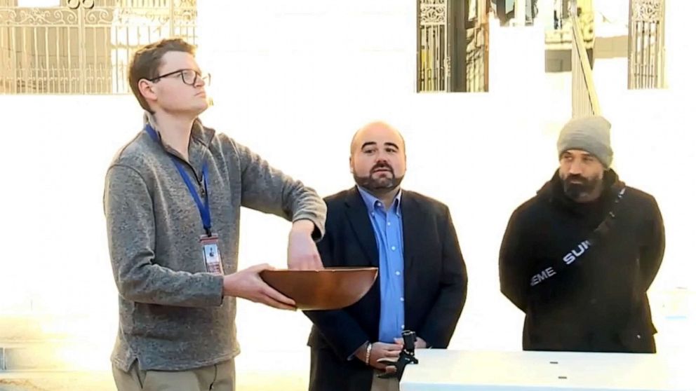 PHOTO: Candidates Brandon Mazer and Roberto Rodriguez, who each won 8,529 votes after tabulation was completed, await the results as the city clerk drew the winning name from a wooden bowl outside City Hall in Portland, Maine, Nov. 4, 2021.