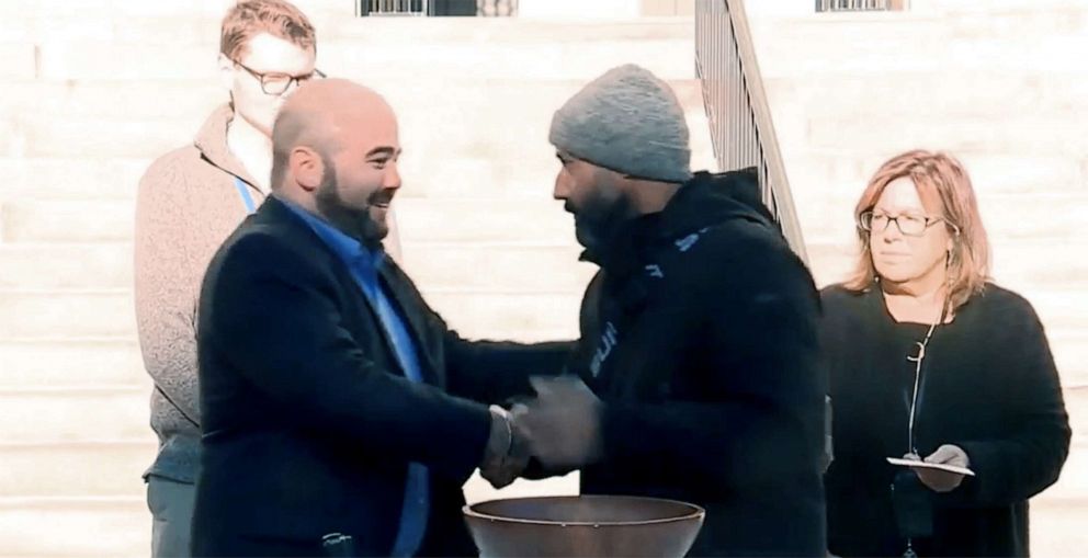 PHOTO: Candidates Brandon Mazer and Roberto Rodriguez shake hands after the city clerk drew Mazer as the winning name from a wooden bowl after the election results were too close to call outside City Hall in Portland, Maine, Nov. 4, 2021.