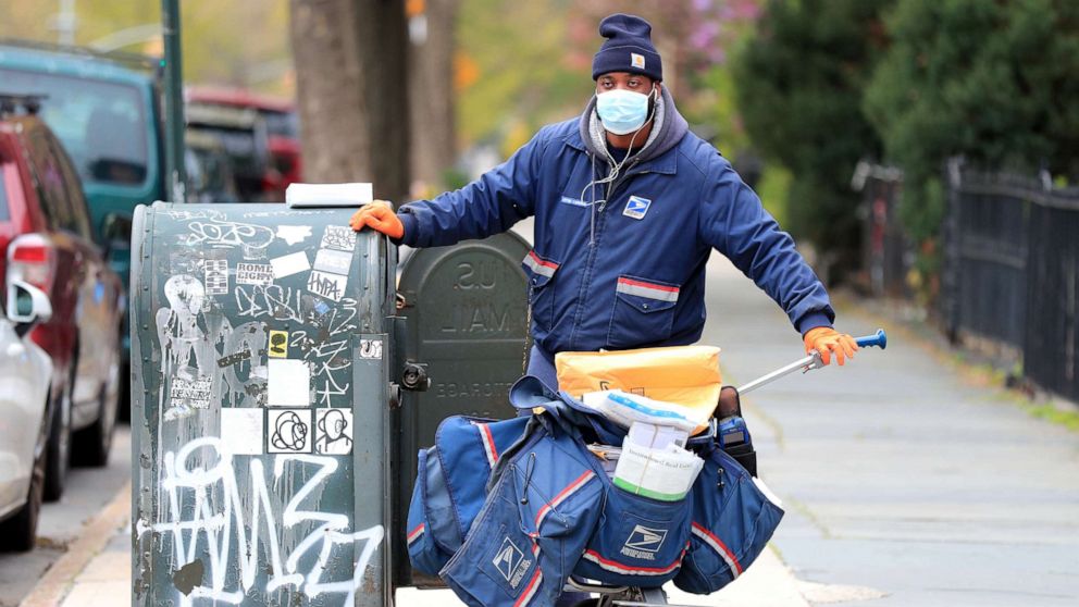 PHOTO: A United States Postal Service worker delivers mail on April 23, 2020, in Brooklyn, New York.