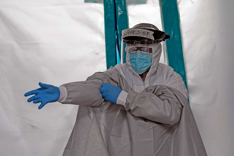 PHOTO: A medical professional puts on personal protective equipment inside the Coronavirus Unit at United Memorial Medical Center, July 6, 2020, in Houston.