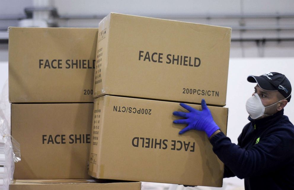 PHOTO: A worker piles up a shipment containing supplies of personal protective equipment (PPE) at Bari airport in Bari, Italy, April 7, 2020.