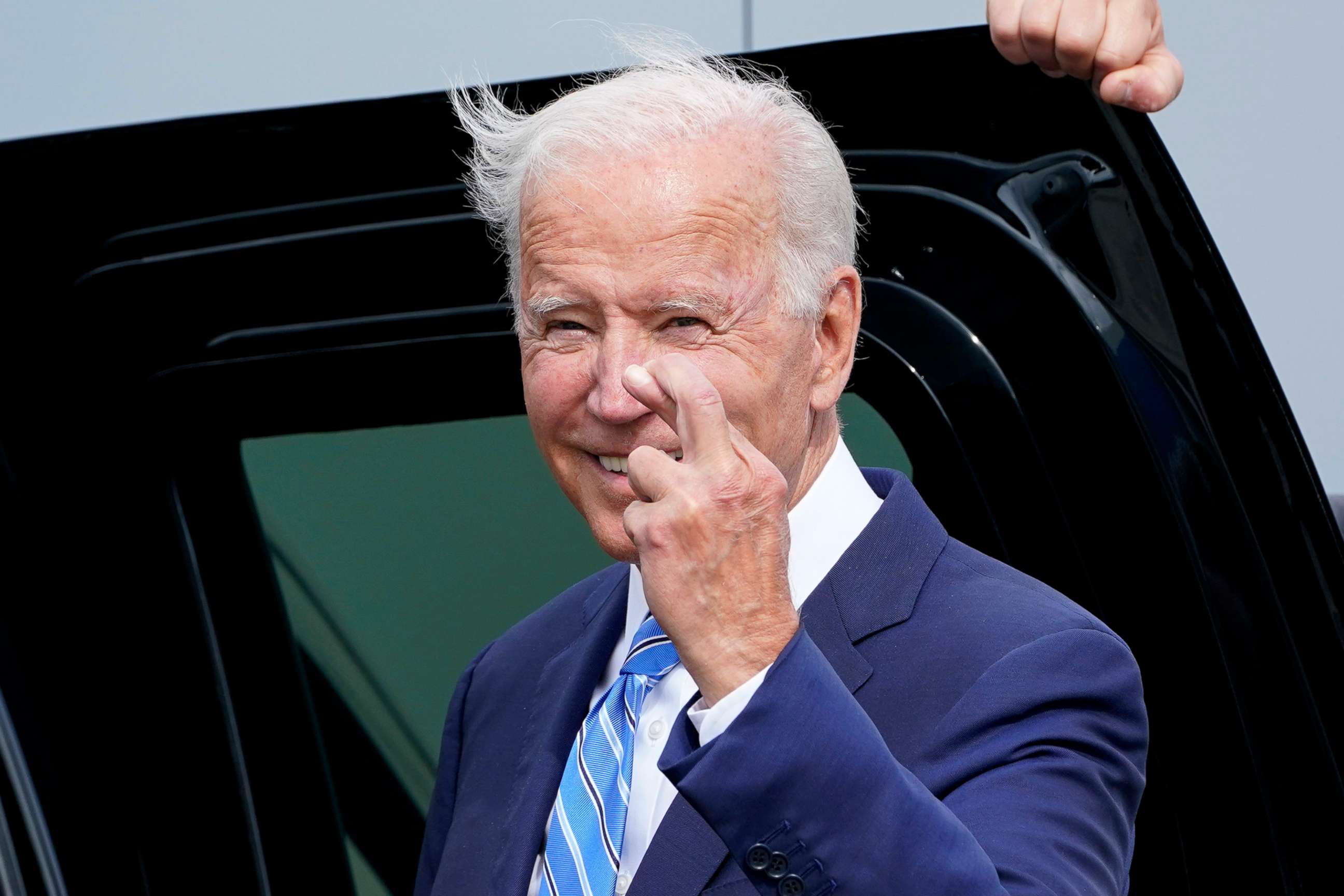 PHOTO: President Joe Biden crosses his fingers as he responds to a question about the short term debt deal, as he arrives at O'Hare International Airport in Chicago, Oct. 7, 2021. 