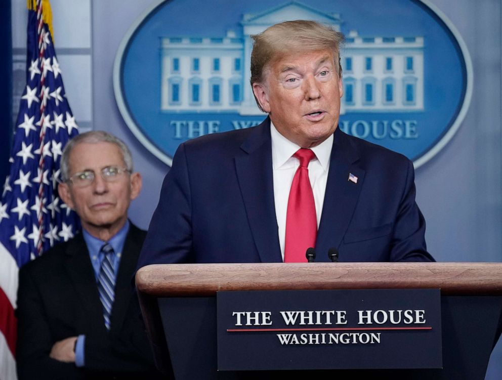 PHOTO: Dr. Anthony Fauci, left, listens to President Donald Trump speak during a briefing on the coronavirus pandemic, in the press briefing room of the White House, March 24, 2020.