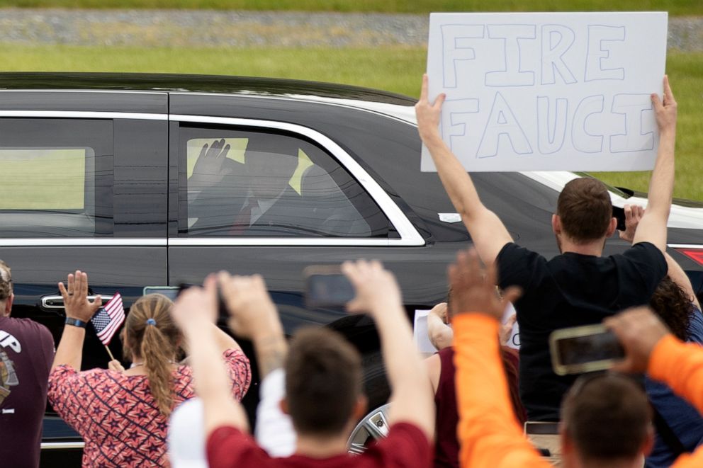 PHOTO: President Donald Trump waves to supporters including one holding a sign reading "Fire Fauci" as his motorcade drives past on May 14, 2020, in Allentown, Pa.