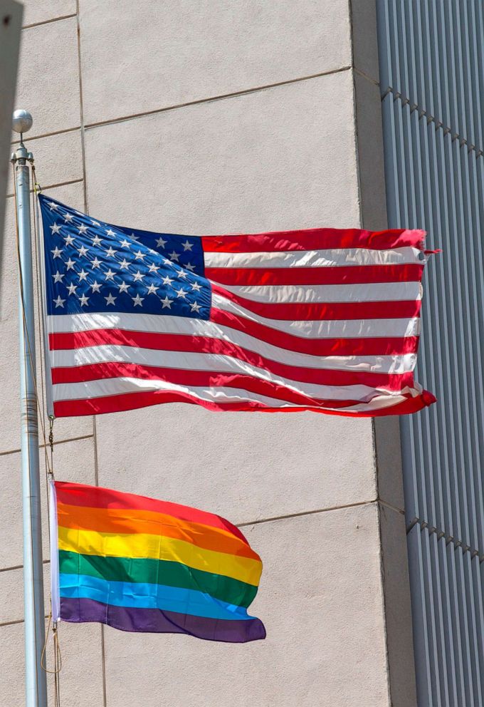 PHOTO: A gay pride flag is raised next to the US flag at the US embassy near the annual gay pride parade in the Israeli coastal city of Tel Aviv on June 13, 2014.