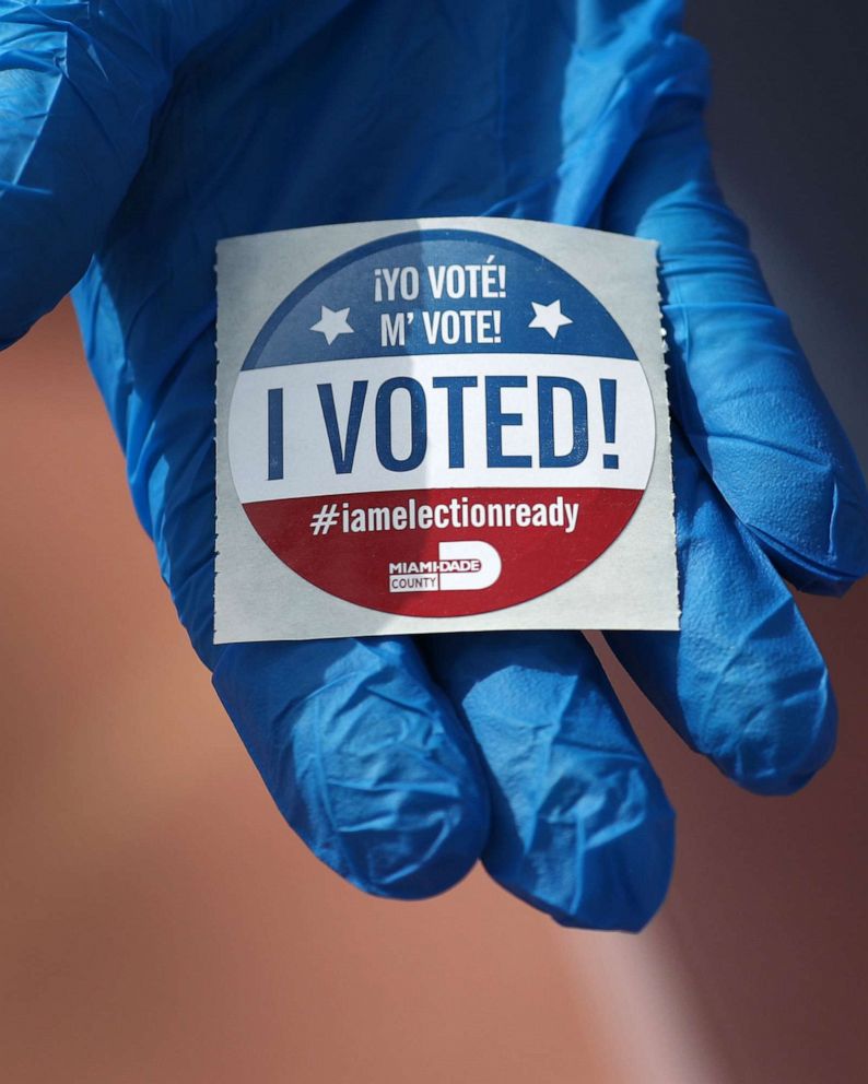 PHOTO: A voter holds an, "I Voted!", sticker after wearing a glove as she cast her ballot during the Florida presidential primary as the coronavirus pandemic continues on March 17, 2020, in Miami Beach, Fla.