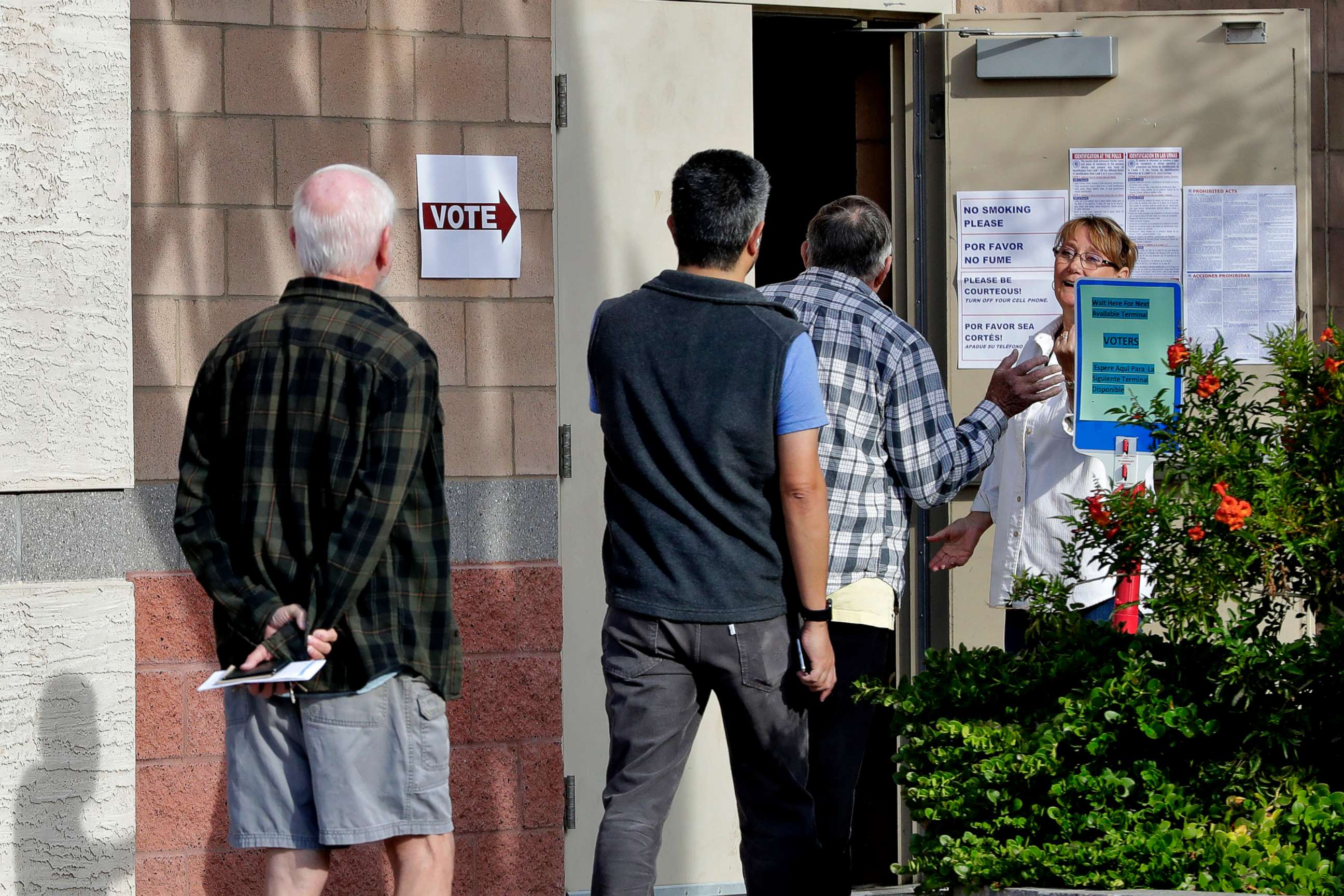 PHOTO: Arizona voters are held outside until other voters leave the polling station prior to casting their ballot in the Arizona presidential preference election Tuesday, March 17, 2020, in Phoenix.