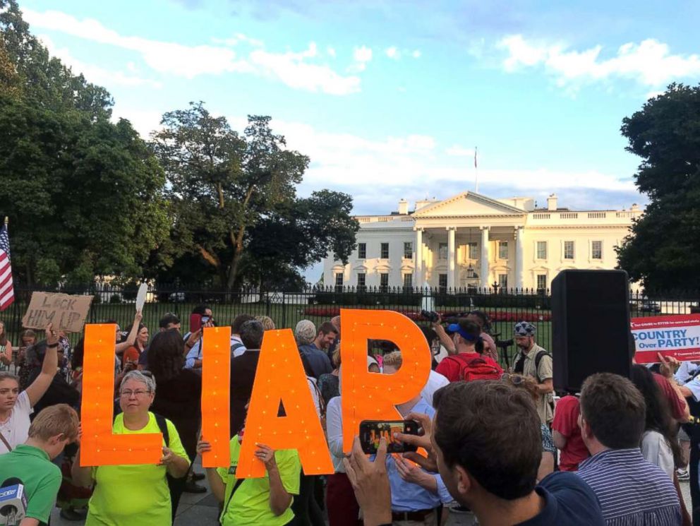 PHOTO: Protesters hold letters to spell out LIAR as they stand in front of the White House.