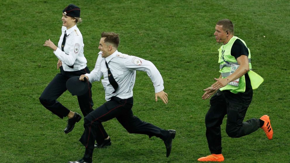 PHOTO: Strikers are chased on the football pitch by a security member during the Russia 2018 World Cup final football match between France and Croatia at the Luzhniki Stadium in Moscow, July 15, 2018.