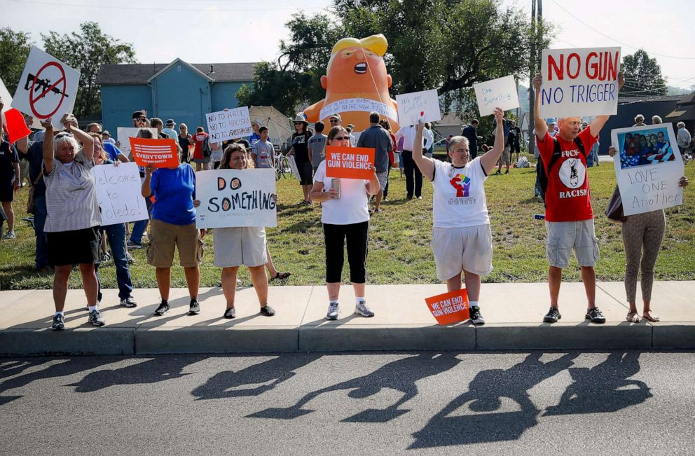 PHOTO: People gather to protest the arrival of President Donald Trump Aug. 7, 2019, outside Miami Valley Hospital after a mass shooting, in Dayton, Ohio.