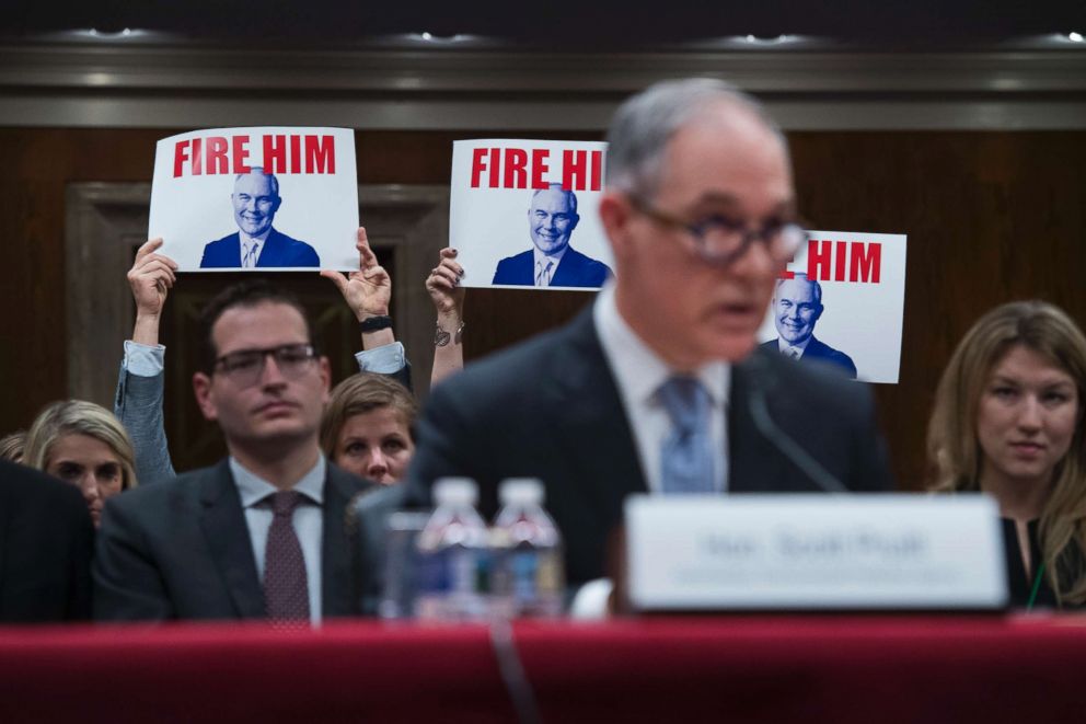 PHOTO: Protesters hold signs as Environmental Protection Agency Administrator Scott Pruitt testifies during a Senate Appropriations Interior, Environment, and Related Agencies Subcommittee hearing in Capitol Hill in Washington, D.C., May 16, 2018.