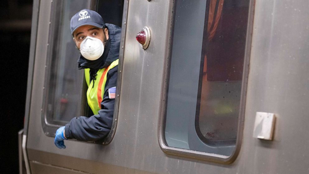PHOTO: A subway train driver wearing a protective mask operates the doors of a Massachusetts Bay Transportation Authority's Blue Line subway car at Maverick Station in Boston, April 24, 2020.