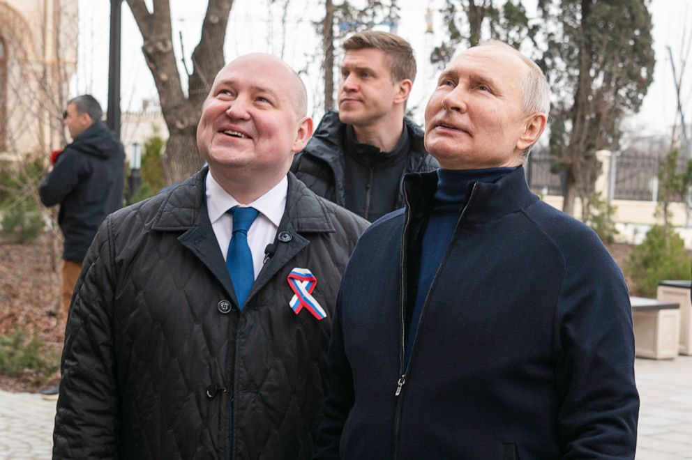 PHOTO: Russia's President Vladimir Putin and Sevastopol Governor Mikhai Razvozhayev visit a children's arts-and-crafts center on the ninth anniversary of the reunification of Crimea with Russia, on March 18, 2023.