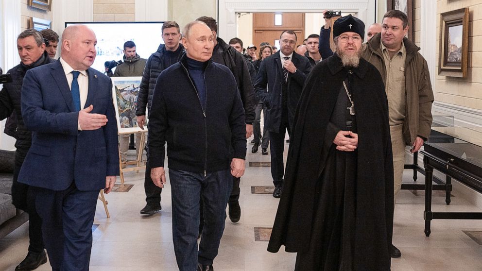 PHOTO: Russia's President Vladimir Putin, Sevastopol Governor Mikhai Razvozhayev, and Metropolitan Tikhon Shevkunov, chairman of the Patriarachal Council for Culture, visit a children's arts-and-crafts center on March 18, 2023.