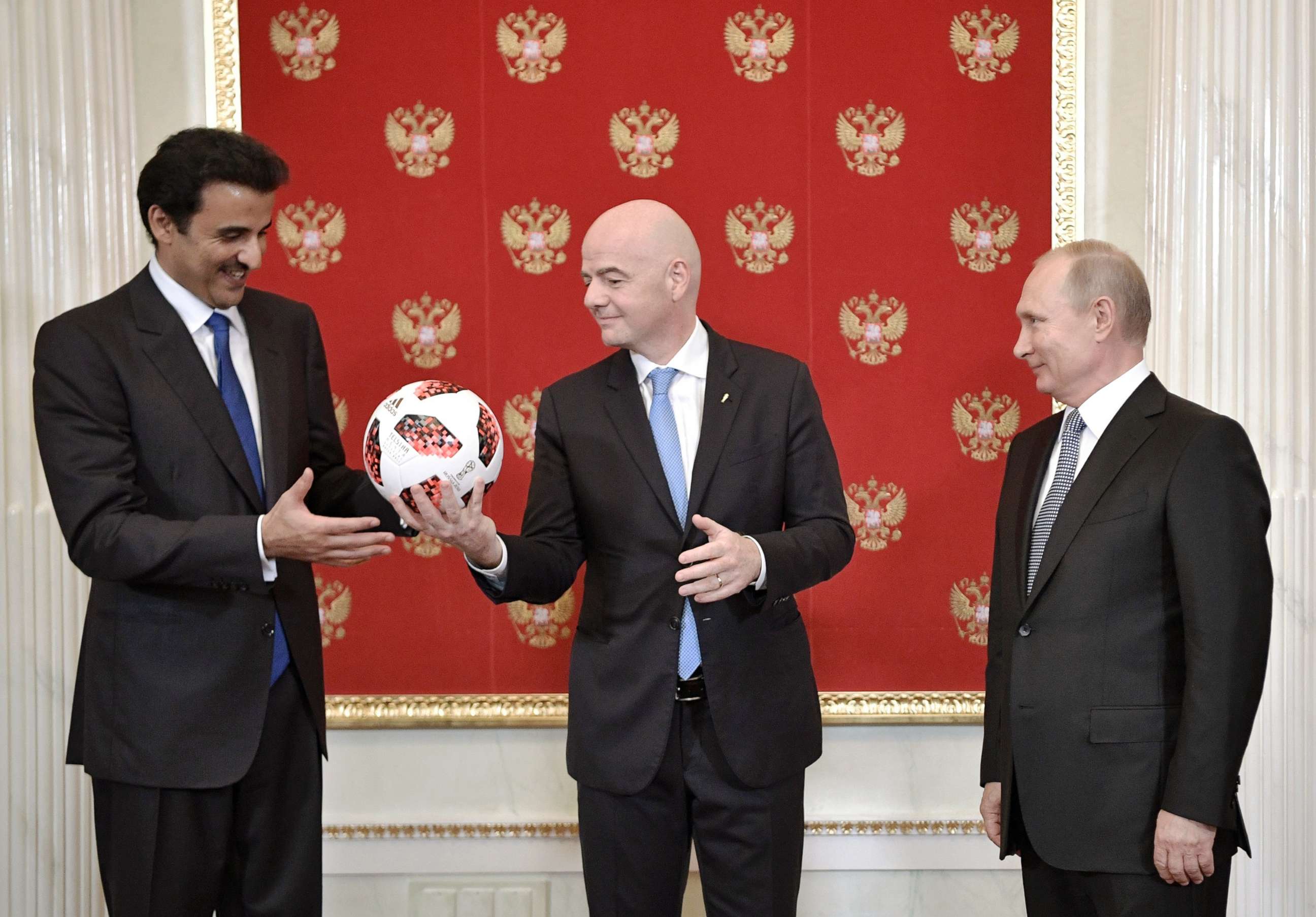 PHOTO: FIFA President Gianni Infantino, center, gives a soccer ball to the Emir of Qatar Sheikh Tamim bin Hamad al-Thani as Russian President Vladimir Putin, stands at right, during their meeting in the Kremlin in Moscow, July 15, 2018.