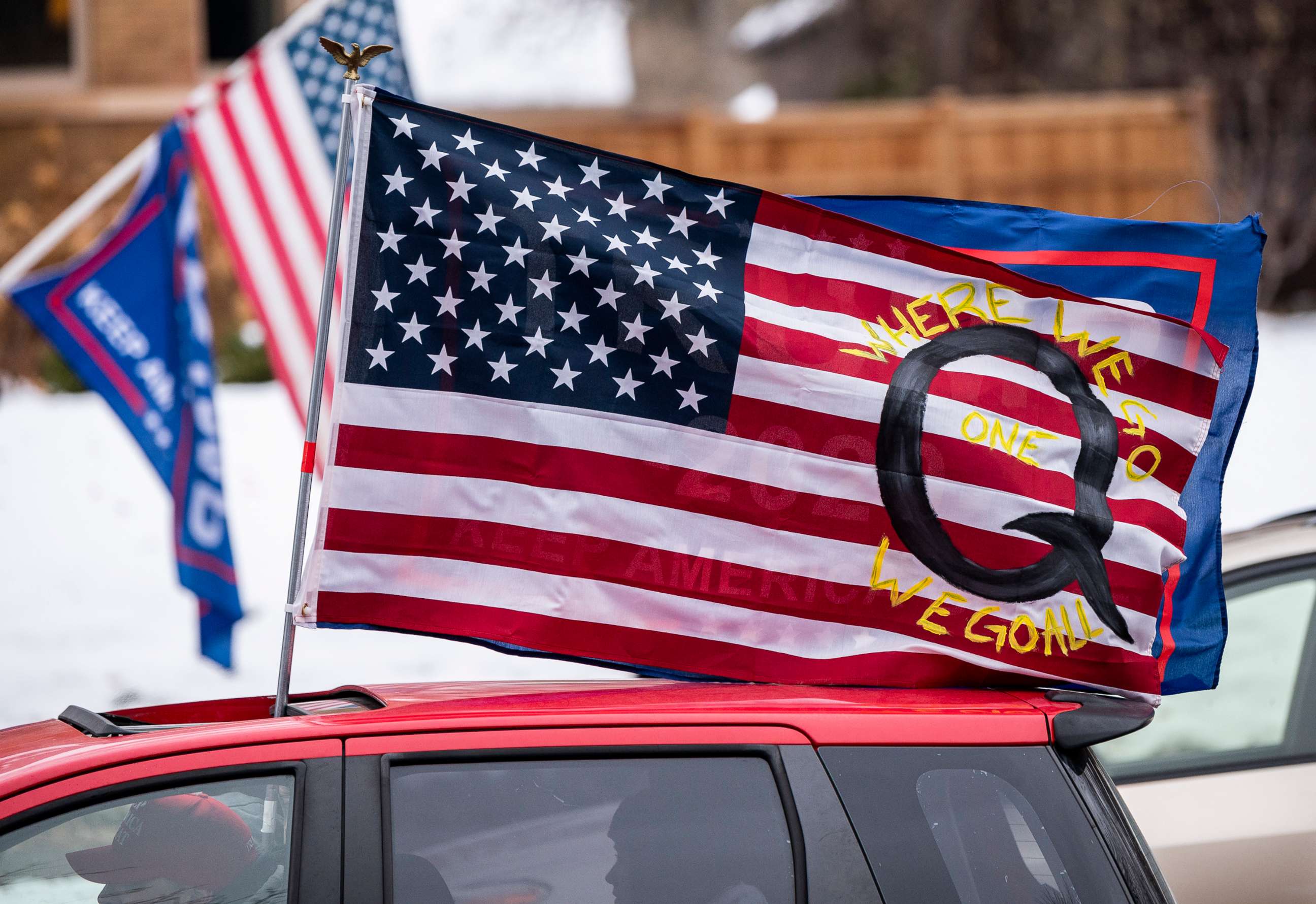 PHOTO: A car with a flag endorsing the QAnon drives by as supporters of President Donald Trump gather for a rally, Nov. 14, 2020, in St. Paul, Minn.