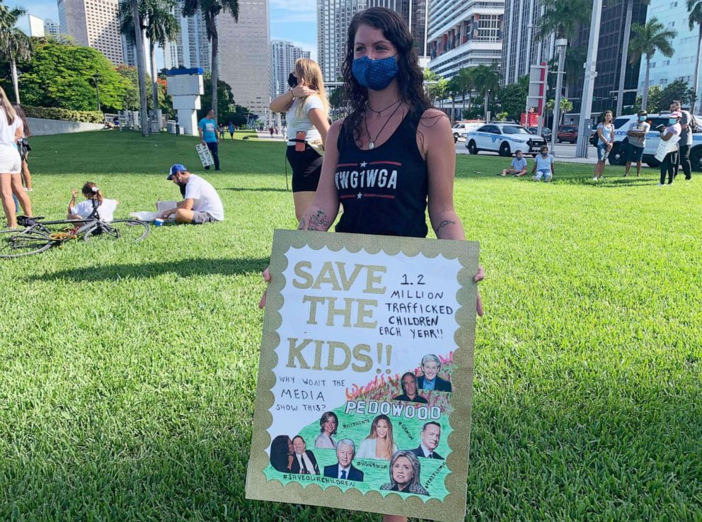 PHOTO: Jenn Luizzi, a 27-year-old QAnon supporter from Deerfield Beach, holds a sign at Bayfront Park during a child sex trafficking rally in Miami, Aug. 22, 2020.