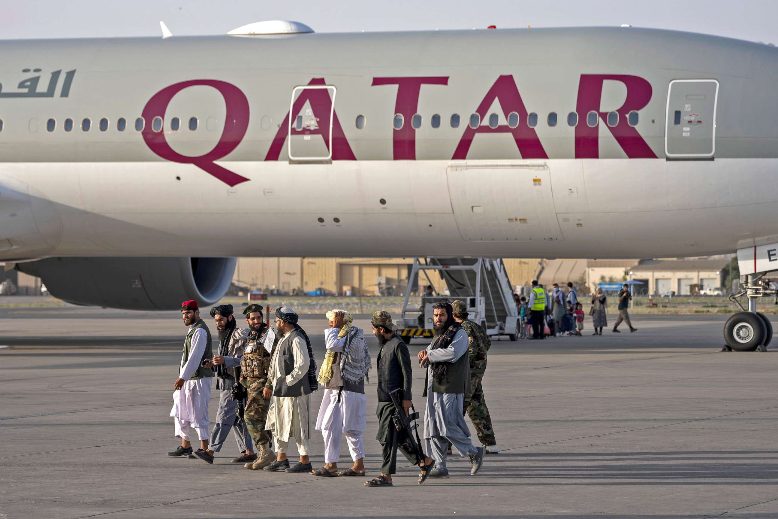 PHOTO: Taliban fighters walk past a Qatar Airways aircraft at the airport in Kabul,  Sept. 9, 2021. Some 200 foreigners, including Americans, flew out of Afghanistan on an international commercial flight from Kabul airport.