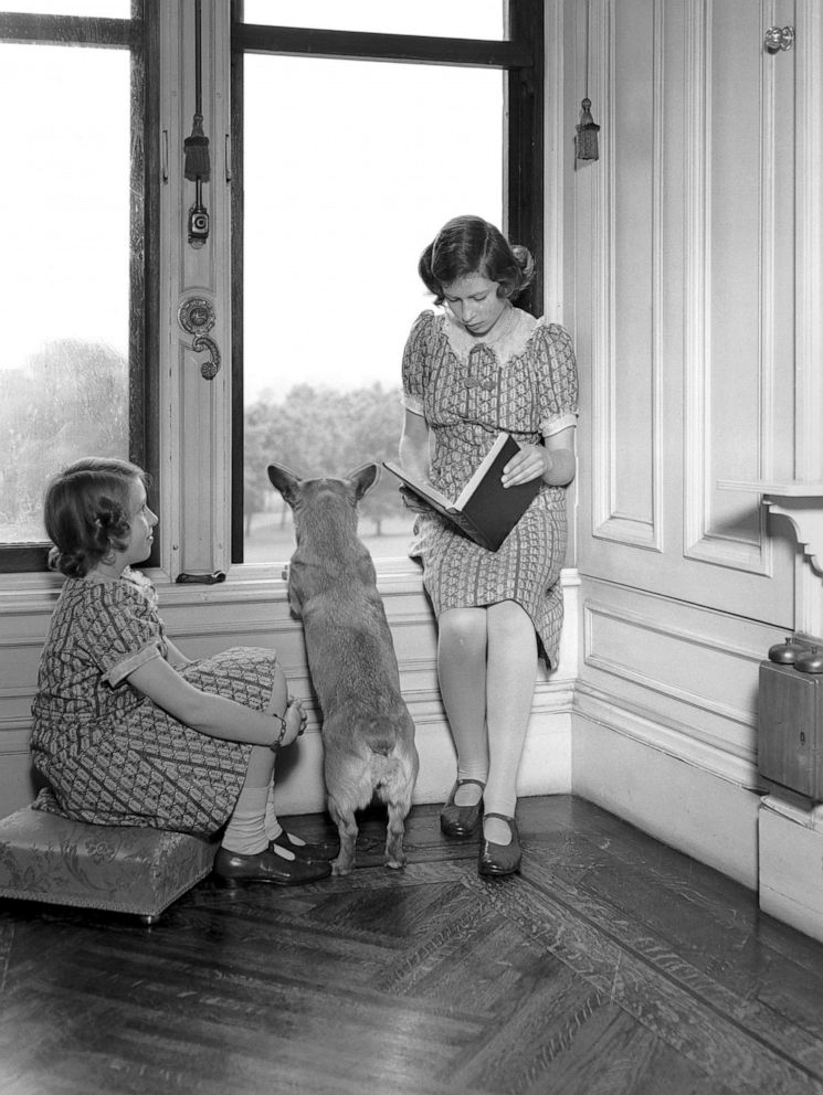 PHOTO: Princess Margaret, left, and Princess Elizabeth read together, while a Corgi peers out of a window at Windsor Castle, June 22, 1940.